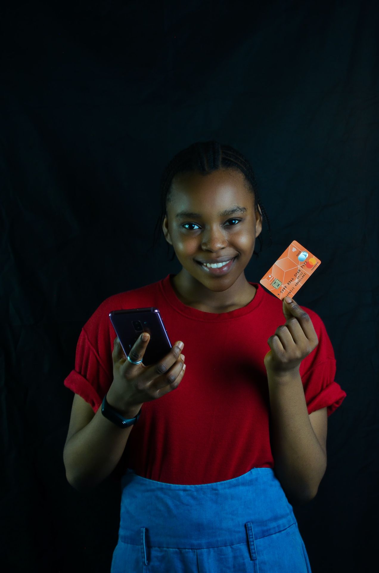 a woman holding a cell phone and a credit card